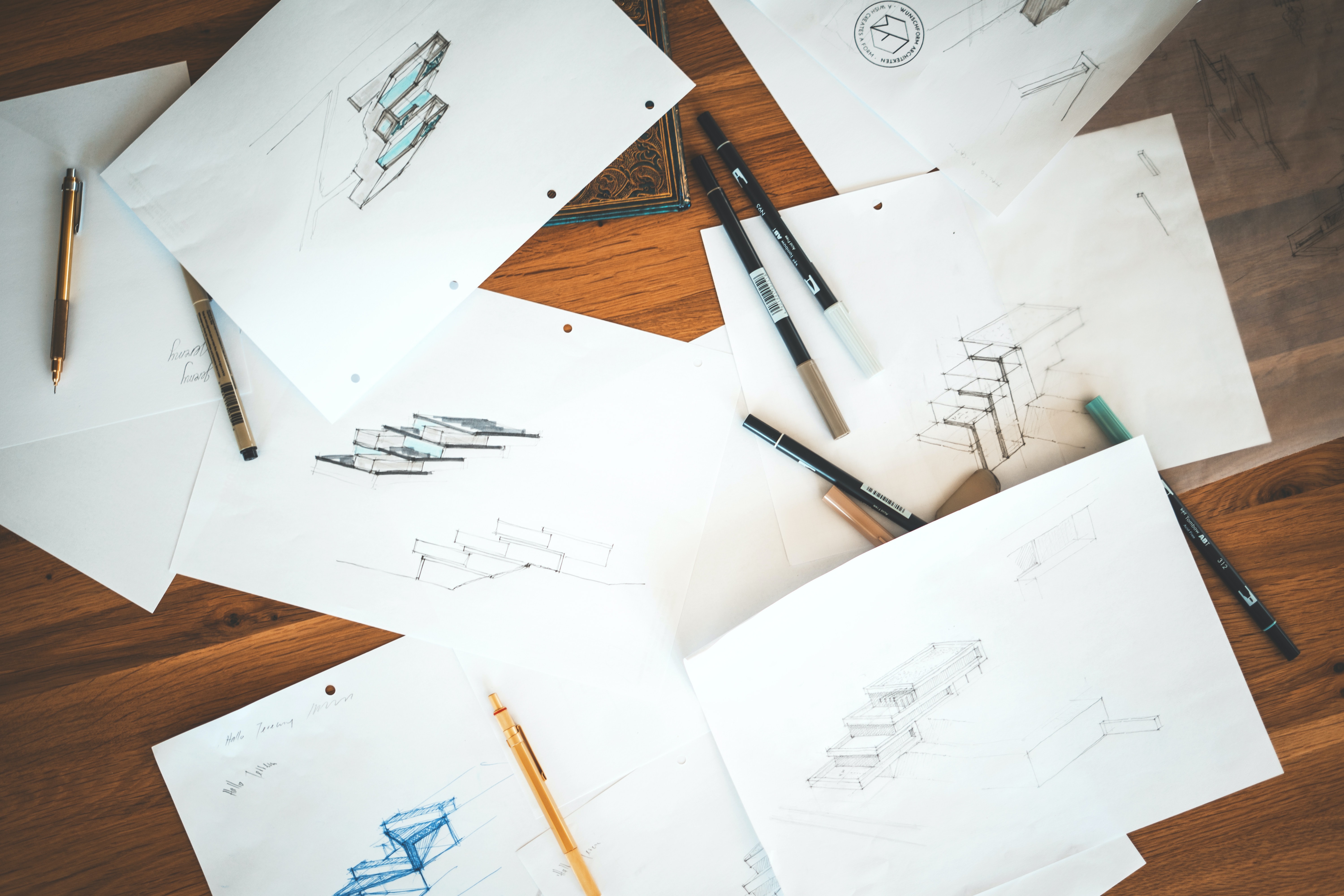 Papers on a desk with sketches of designs.